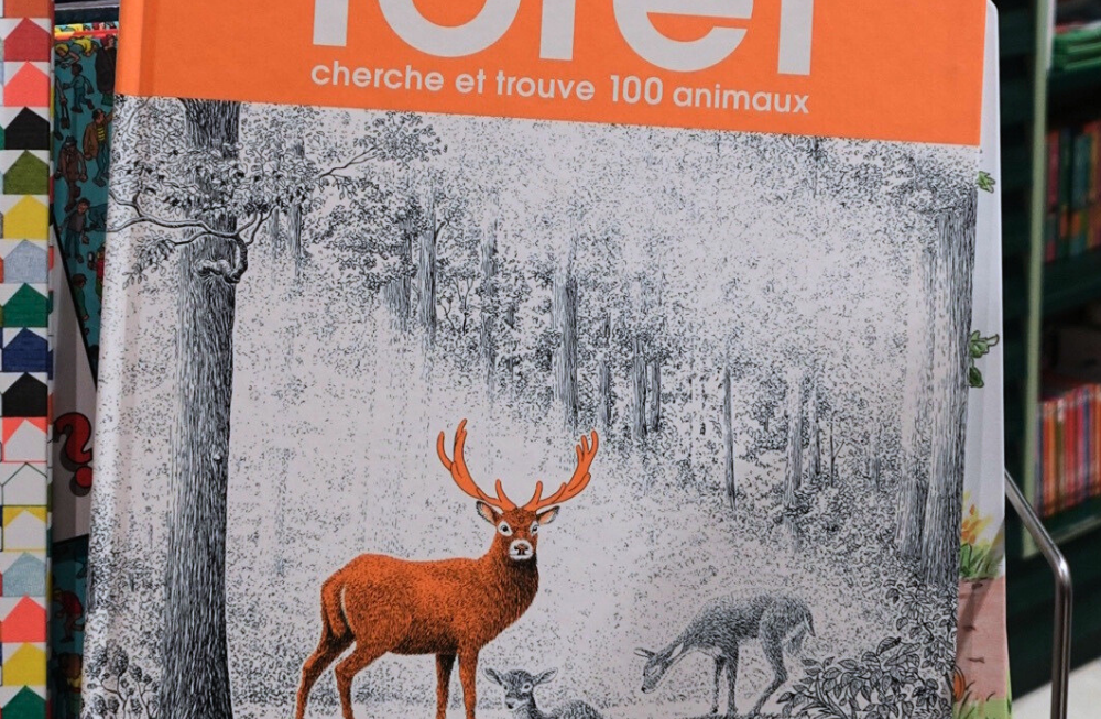 Un grand livre en noir et blanc avec un cerf en orange (et le titre en orange)